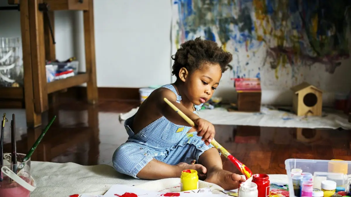 criança negra brincando com tinta 