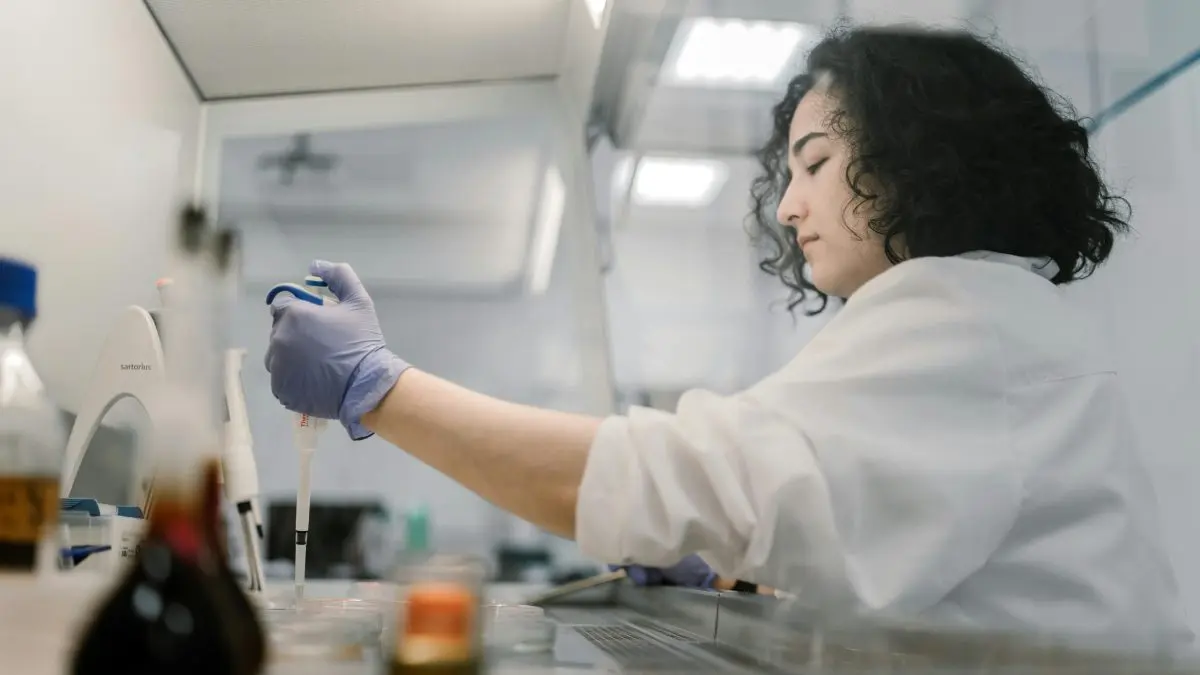 Cientista manipulando uma amostra em um laboratório. 
